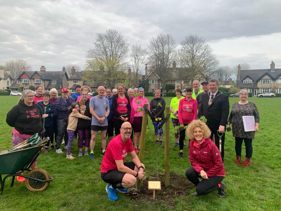 A group of men and women pose with the newly-planted rowan tree at East Hull Fitmums & Friends