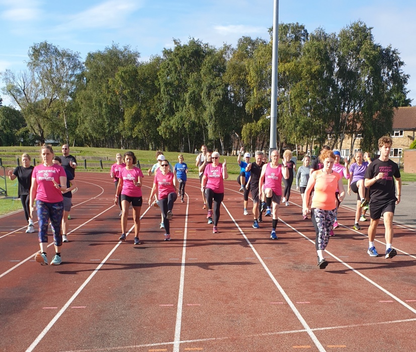 A group of men and women doing drills on an athletics track