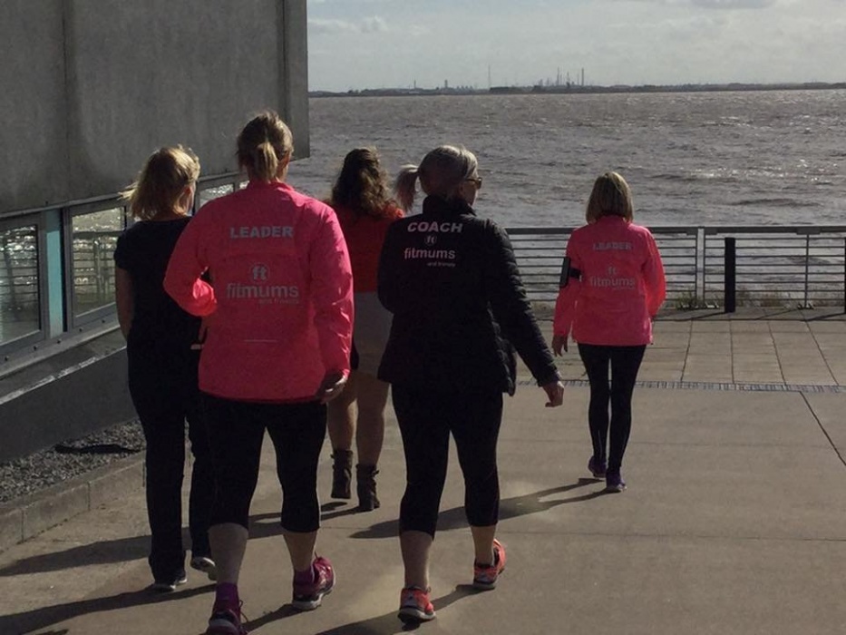 A group of people walking by a river.