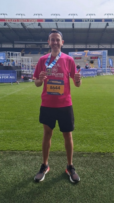 Paul smiling and wearing a medal after a race.