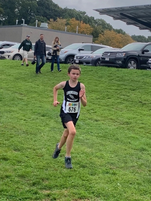 Noah running cross country in his Longmeadow vest.