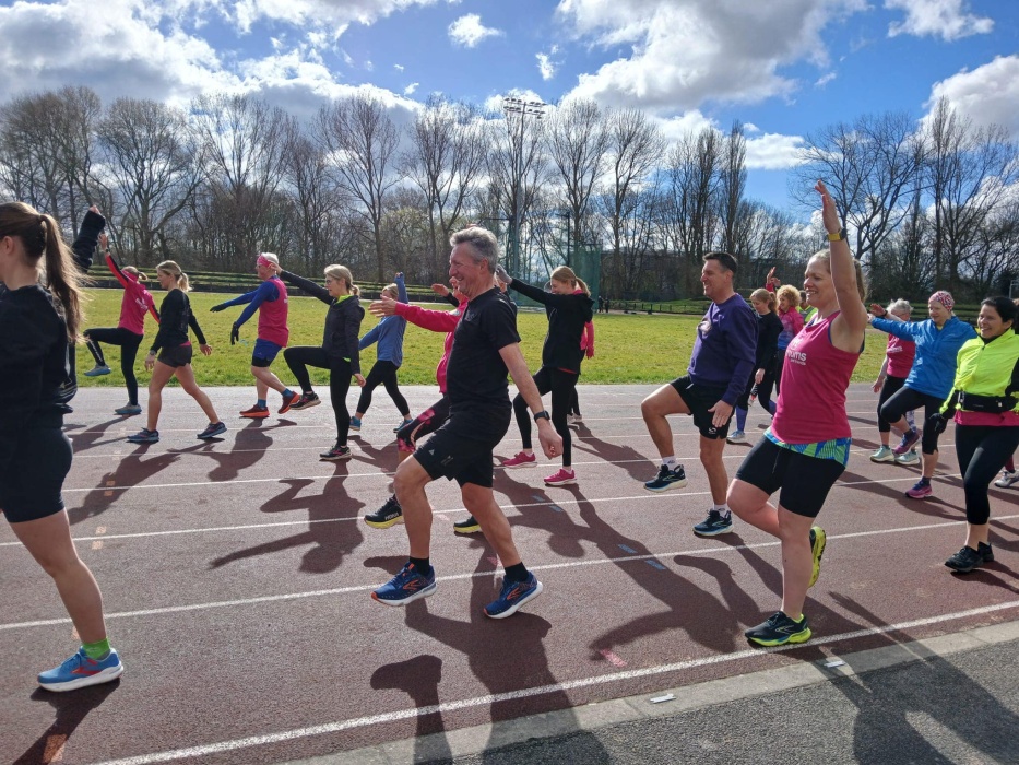 A group of men and women doing drills on an athletics track