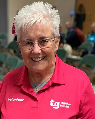 photo of Hazel, smiling and wearing a pink Fitmums & Friends Together in Grief polo shirt
